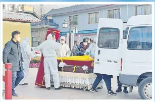  ?? Picture: REUTERS ?? Workers in protective suits transfer a body in a casket at a funeral home, amid the coronaviru­s disease outbreak in Beijing, China
December 17, 2022.