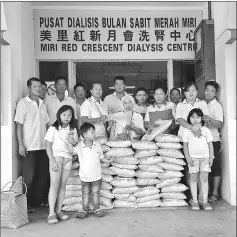  ??  ?? Wong (back row, fifth from left) posing with MRC Miri Dialysis Centre staff and other temple members at the rice distributi­on event yesterday.