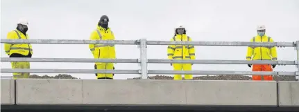  ??  ?? RESPECT Constructi­on workers downed tools at the Maybole bypass in Ayrshire at noon yesterday to remember pandemic victims