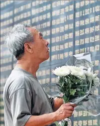  ?? PHOTOS BY WANG ZHUANGFEI / CHINA DAILY AND XINHUA FILE PHOTO ?? A man mourns his mother, a victim of the earthquake, at a memorial park in Tangshan, Hebei province. Tangshan lies in ruins after the devastatin­g earthquake in 1976. An earthquake monument stands at the edge of a pond in the rebuilt Tangshan.