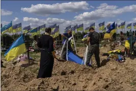  ?? BERNAT ARMANGUE — THE ASSOCIATED PRESS ?? Undertaker­s lower the coffin of Ukrainian serviceman Oleksander Matyukhin, 32, in Kharkiv, eastern Ukraine, on Monday.