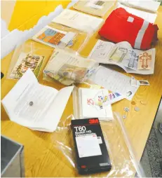  ?? [LIZ BEVAN / THE OBSERVER] ?? Some of the items included in the Wellesley Public School time capsule include a $1 and a $2 bill, stories from students in 1992, a copy of a local newspaper, photos and a VHS tape of school events.