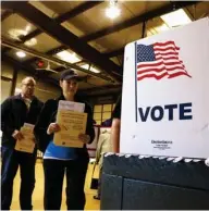  ?? (Photo by Seth Perlman, AP) ?? In this March 15, 2016, file photo, people line up to vote in the primary at a precinct in Bradfordto­n, Il. State election officials from across the U.S. are gathering this weekend in Indianapol­is amid an uproar over a White House commission...