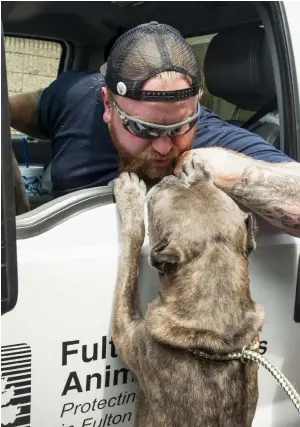  ??  ?? ABOVE: Officer Nick Foley gets kisses from a dog.