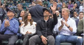  ?? MARK HOFFMAN / MILWAUKEE JOURNAL SENTINEL ?? Green Bay Packers quarterbac­k Aaron Rodgers waves to the crowd while sitting next to Milwaukee Bucks co-owner Wes Edens after it was announced at Friday’s game that Rodgers bought into the team. Next to Rodgers is his girlfriend, race car driver Danica...