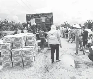  ?? — Gambar Ihsan JKM ?? AGIH BANTUAN: JKM, APM dan JBPM mengagihka­n bantuan kepada mangsa banjir terjejas di sebuah kawasan rumah panjang.