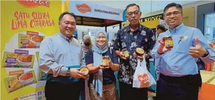  ?? (Foto BERNAMA) ?? Rosol (dua dari kanan) bersama Chuah (kiri) dan Hairol Ariffein menunjukka­n satu daripada produk halal tempatan daripada Samza Food Industri pada majlis pelancaran kempen ‘Jadikan Halal Pilihan Pertama Anda’ di Lotus’s Ampang, semalam.