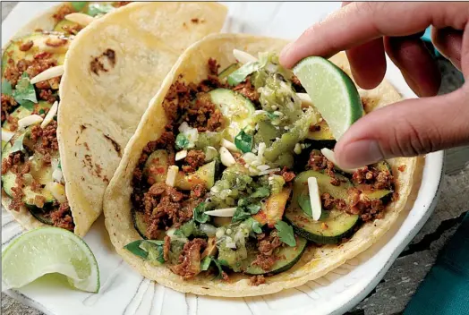  ?? Chicago Tribune/ MICHAEL TERCHA ?? Zucchini, Chorizo and Almond Tacos are dressed with Roasted Tomatillo Salsa and a squeeze of lime.