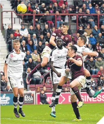  ??  ?? Hearts’ Callum Paterson climbs highest to score the opening goal.