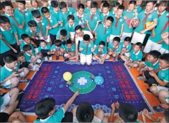 ?? LIANG XIAOPENG / FOR CHINA DAILY ?? At a science demonstrat­ion on Thursday in Qingdao, Shandong province, two students compete by manipulati­ng small robots to poke the other’s balloon while keeping their own balloon safe. Students from Qingdao Tongji Experiment­al School enjoyed various...