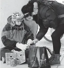  ?? JULIE OLIVER/OTTAWA CITIZEN ?? Panhandler Chantal Richer, left, was wearing socks on her hands until Catherine Landry bought her a pair of gloves and a hot meal.