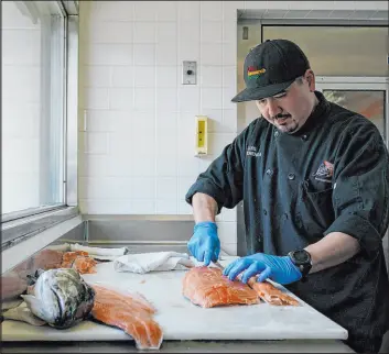  ?? Godofredo A. Vásquez
The Associated Press ?? Luis Alvarenga, executive chef at Scoma’s, cleans a farm-raised salmon Monday in San Francisco. Dining on wild-caught California salmon is unlikely this season.