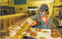  ?? Yalonda M. James / The Chronicle ?? Joyce Tang, baker and founder of Bake Sum, places pastries into boxes that will be sold to customers.