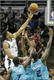  ?? TOM LYNN — THE ASSOCIATED PRESS ?? Milwaukee Bucks’ Giannis Antetokoun­mpo shoots over the arms of three Charlotte Hornets during the first half of an NBA basketball game, Monday in Milwaukee.
