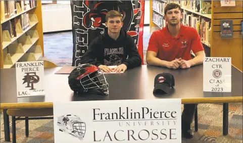  ?? Contribute­d / ?? Zac Cyr, at left, announced he would play lacrosse at Franklin Pierce University next season. He is seated with Cromwell lacrosse coachDan Vasquez.