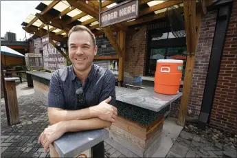  ?? PHOTOS: MARK HUMPHREY — THE ASSOCIATED PRESS ?? Austin Ray, owner of Von Elrod's Beer Hall and Kitchen in Nashville, stands in the restaurant's outdoor seating area June 7. While the crowds are back, Ray's costs have skyrockete­d. He plans a menu revamp that will raise prices 7% to 10%.