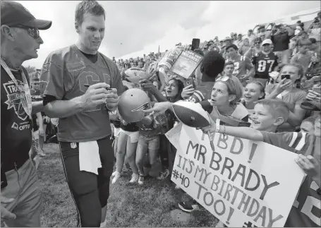  ?? STEVEN SENNE/AP PHOTO ?? Patriots quarterbac­k Tom Brady signs autographs for fans Thursday at training camp in Foxborough, Mass. Brady turned 40 on Thursday.