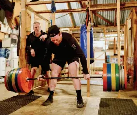  ??  ?? TOP / Cathy, a member of the Woolshed Gym for many years, shares a lightheart­ed moment with Allan whilst reflecting on previous training experience­s. ABOVE / ‘He’s the heavyweigh­t of the gym!’ Allan compliment­s longtime member Josh Pitt, after performing an impressive 230 kg deadlift.
OPPOSITE / Opening time: Allan opens the gym on a frosty, freezing morning.