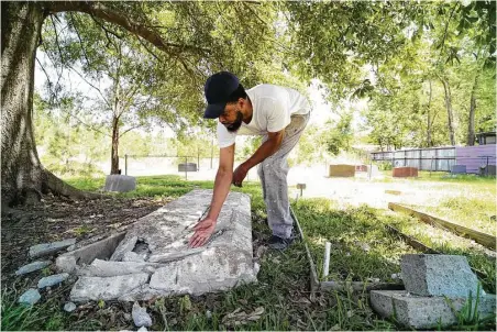  ?? Godofredo A. Vasquez / Houston Chronicle ?? Rod Barnaba inspects the damage to a gravestone after someone drove through part of the historical Barrett Station Evergreen Cemetery over the weekend. The graves of Barnaba’s family members were undisturbe­d.