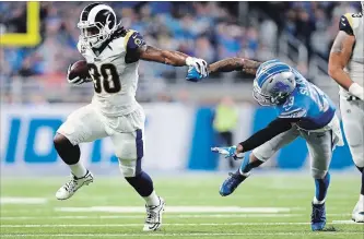  ?? REY DEL RIO THE ASSOCIATED PRESS ?? Los Angeles Rams running back Todd Gurley (30) pushes Lions cornerback Darius Slay during the first half Sunday in Detroit. Gurley rushed for 132 yards and two touchdowns for the now 11-1 Rams.