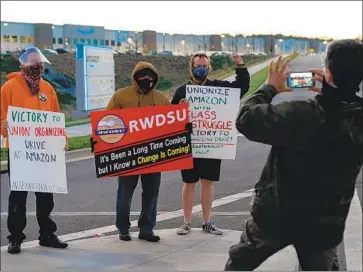  ?? Elijah Nouvelage Getty Images ?? SUPPORTERS of the Retail, Wholesale and Department Store Union pose near the Amazon facility in Bessemer, Ala., last month. The union alleges intimidati­on and unfair practices by Amazon during the campaign.