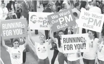  ?? AFP PHOTO ?? Supporters of Lebanon’s former prime minister Saad Hariri hold up placards demanding his return from Saudi Arabia on the starting line of Beirut’s annual marathon on November 12, 2017. Hariri announced on November 4 in a televised statement from Riyadh...