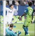  ??  ?? Vancouver Whitecaps’ Christian Bolanos celebrates teammate Fredy Montero’s goal past Seattle Sounders goalkeeper Stefan Frei as Sounders’ Oniel Fisher looks away during the second half of an MLS soccer match on April 14, in Vancouver, British...