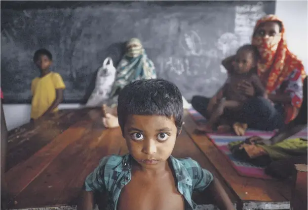  ??  ?? 0 A yound resident rests with others in a shelter ahead of the expected landfall of cyclone Amphan in Bangladesh