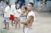  ?? — Reuters ?? An evacuated resident carries a child at an evacuation centre in Iligan, while government forces fight insurgents from the Maute group in Marawi, on Tuesday.