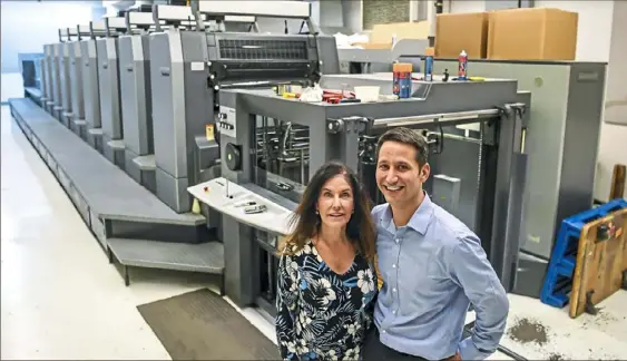  ?? Alexandra Wimley/Post-Gazette ?? Adrienne Mallet and her son, Matt Mallet, who is now the president of Broudy Printing, stand in front of their newest printing press in East Liberty.