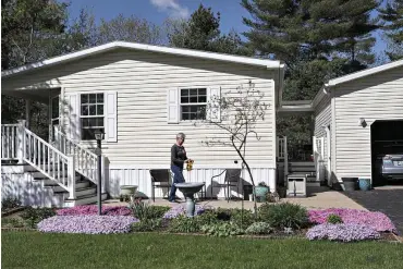  ?? Photo for The Washington Post by Cheryl Senter ?? ■ Sue Veal, 69, gardens at home May 17 in Rochester, N.H. Veal moved to a mobile home park six years ago, after her husband died. She bought the home for $119,000 but says lot rent has gone up from $395 a month to more than $480 since she moved in.