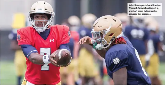  ??  ?? Notre Dame quarterbac kB randon Wimbush (shown handing off in practice) needs to improve his accuracy thiss eason.AP