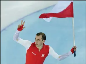  ?? The Associated Press ?? BRODKA TONIC: Gold medalist Poland’s Zbigniew Brodka holds his national flag and celebrates after the men’s 1,500- meter speedskati­ng race during the 2014 Winter Olympics Saturday at the Adler Arena Skating Center in Sochi, Russia. Brodka won while the...