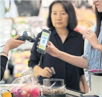  ??  ?? BREAKING BANK: A customer has a QR code scanned from a smart phone at a grocery store in Bangkok. Thailand has stepped up efforts to curb the use of cash, with banks following suit.