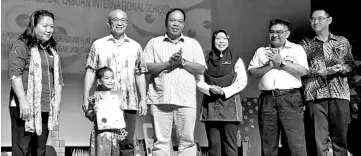  ??  ?? Rozman (fifth right) presenting appreciati­on certificat­e to the representa­tive of the 175 students who performed at the Smile-The Window of Communicat­ion programme at the Labuan Internatio­nal School yesterday. Baharin is at fourth right.