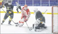  ?? JEREMY FRASER/CAPE BRETON POST ?? Josh MacKay, middle, of the Riverview Redmen redirects a shot in front of Spencer Shebib, right, of the Memorial Marauders as Josh Capstick, left, looks on during Cape Breton High School Hockey League action at the Cape Breton County Recreation Centre,...