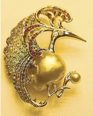  ??  ?? Pamana: Believed to be a messenger of good luck, the gem-encrusted Sarimanok presents a golden South Sea pearl.