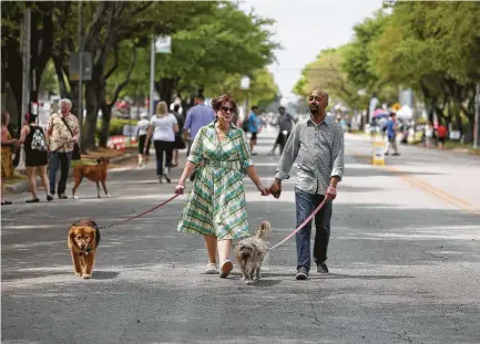  ?? Yi-Chin Lee / Houston Chronicle ?? Chris Stephens and Gerald Sampson walk Keely, left, and Daisy on 19th Street in the Heights during the Cigna Sunday Streets event, which blocked motor vehicles from a reserved stretch of street, allowing for walking, cycling and socializin­g.