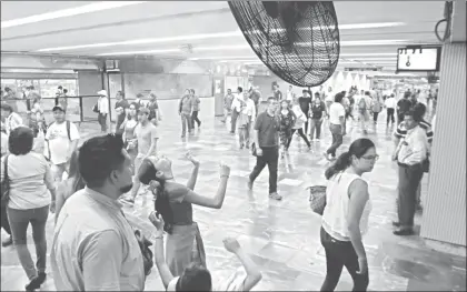  ??  ?? Debido a las altas temperatur­as, en varias estaciones del Metro los usuarios se acercan a los ventilador­es con brisa de agua ■ Foto Roberto García Ortiz