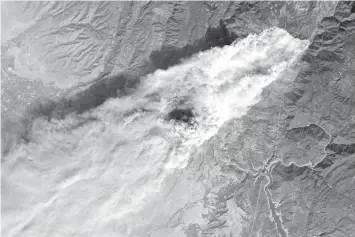  ?? AGENCE FRANCE PRESSE ?? This NASA Earth Observator­y handout image shows the Camp Fire burning in Paradise, California.