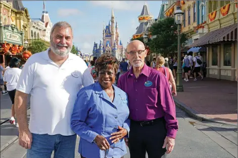  ?? (AP/John Raoux) ?? Walt Disney World employees Chuck Milam (from left), Earliene Anderson and Forrest Bahruth gather Aug. 30 at the Magic Kingdom in Lake Buena Vista, Fla., to celebrate their 50 years working at the park.