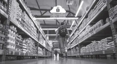  ?? CREDIT: Bloomberg News ?? In this June 20, 2019 photo, people walk along an aisle lined with shelves of consumer goods. Economists forecast that, with inflation hitting high again in June, the US Federal Reserve would stay aggressive in raising rates.