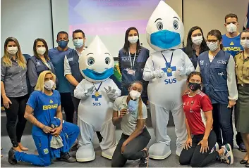  ?? — AP ?? Brazilian athletes, health workers and military officers pose for a photo with Covid-19 vaccinatio­n mascot named “Ze Gotinha,” or Joseph Droplet, after the athletes got shots of the Pfizer vaccine at Urca military base in Rio de Janeiro, Brazil, on Friday.