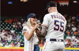  ?? Karen Warren/Staff photograph­er ?? Kat Pressly, wife of Astros relief pitcher Ryan Pressly, talks with her husband after throwing out the first pitch to him at a game last year.