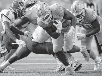  ?? ROBERT WILLETT/ASSOCIATED PRESS ?? North Carolina's Javonte Williams (25) rushes for a first down against N.C. State in the first half Saturday in Chapel Hill. He registered three touchdowns in the 14th-ranked Tar Heels' 48-21 victory over the 23rd-ranked Wolfpack at Kenan Stadium.