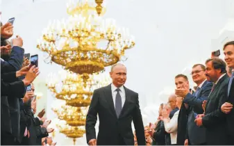  ?? Alexander Zemlianich­enko / Associated Press ?? Vladimir Putin strides through the Kremlin before the inaugurati­on ceremony for his fourth term as Russia’s president. In his speech, Putin said his focus will be on domestic matters.