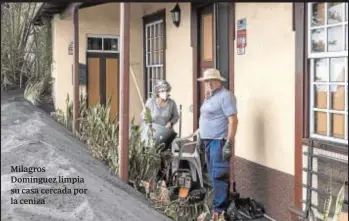  ?? ?? Milagros Domínguez limpia su casa cercada por la ceniza