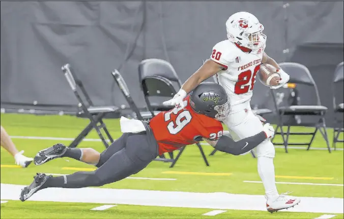  ?? Erik Verduzco Las Vegas Review-Journal @Erik_Verduzco ?? Fresno State’s Ronnie Rivers, who rushed for 133 yards and three touchdowns, tries to shake a tackle by Rebels defensive back Tre Caine in the second quarter.