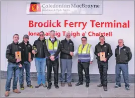  ??  ?? Photo: Brian Donlin Bill Barr of Arran RNLI thanks CalMac’s Colin McCort for their fundraisin­g efforts, while the RNLI crew show off their new gear.