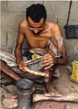  ??  ?? A Yemeni man carves a wooden handle for new daggers made from metal salvaged from fallen rockets in air strikes.